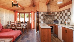 Un intérieur en bois comprenant une cuisine, un coin repas et un lit.