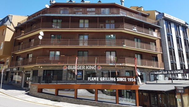 Un hôtel à plusieurs étages doté de balcons, un restaurant Burger King et un bar-restaurant.