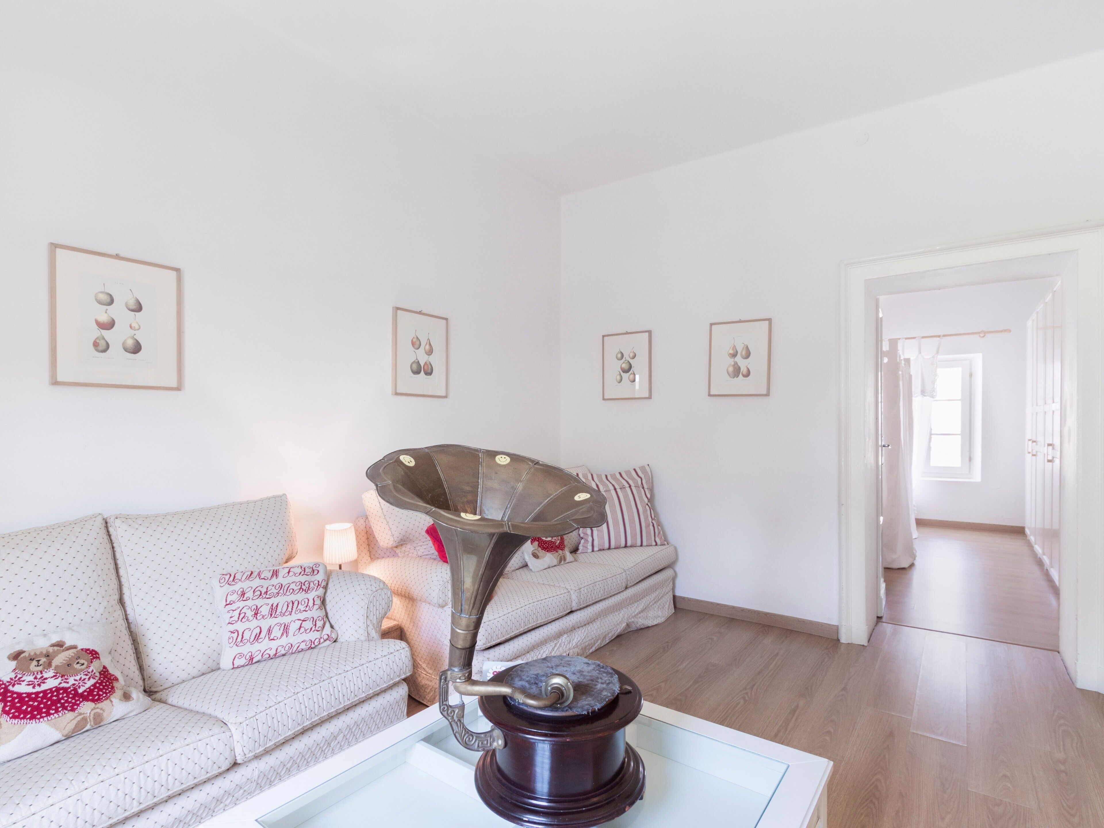 A living room with a sofa, a decorative lamp, and framed wall art.