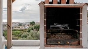 Barbecue in mattoni all'aperto con vista su una zona residenziale.
