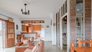 Un soggiorno con un divano, un tavolo da pranzo e una cucina sullo sfondo.