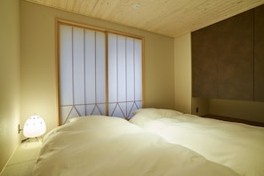 Un dormitorio con una cama, una lámpara de pared y una puerta corredera.