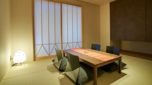 Ein traditioneller japanischer Raum mit Tatami-Böden, einem niedrigen Holztisch und Shoji-Schirmwänden.