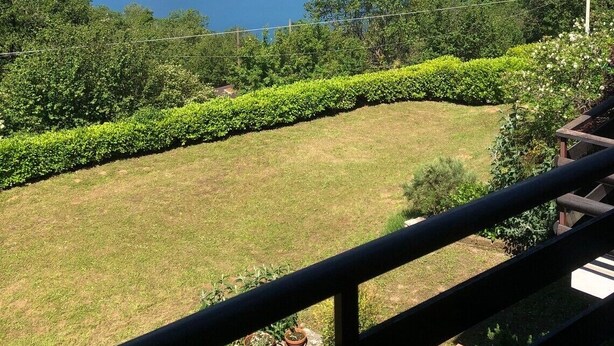 A balcony with a view of a lake, mountains, and a clear sky. - Cozy Apartment with Balcony, Lake View & Wi-Fi; Parking Available, Pets Welcome (San Zeno di Montagna)