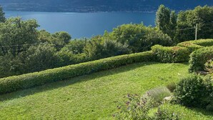 A mountainous landscape with a lake, lush greenery, and a clear sky. - Cozy Apartment with Balcony, Lake View & Wi-Fi; Parking Available, Pets Welcome (San Zeno di Montagna)