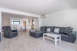 En moderne stue med sofa, lænestol og sofabord.