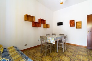 Un'area pranzo con tavolo, sedie e pavimento decorato.