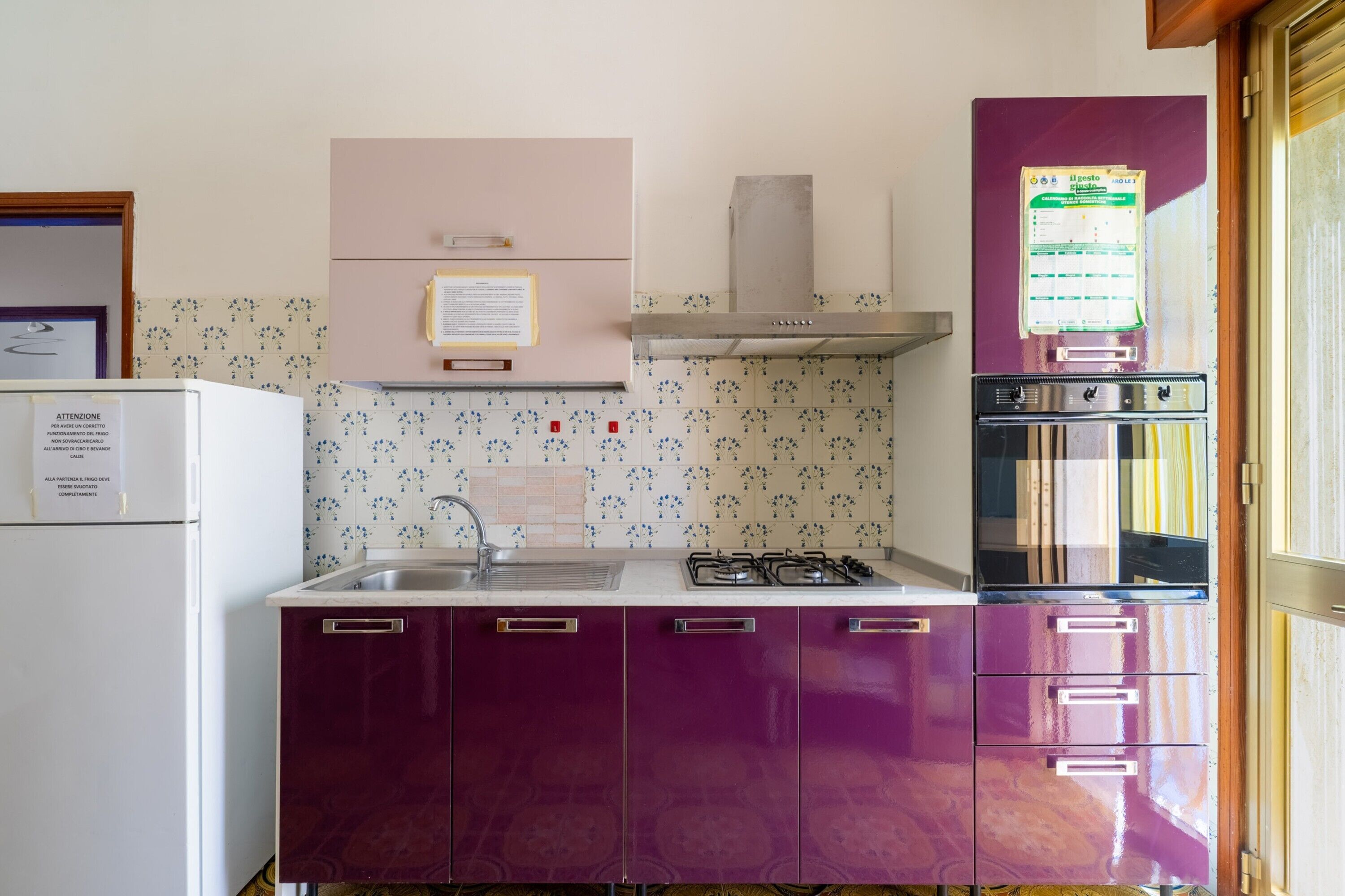 A kitchen with a sink, stove, and cabinets.