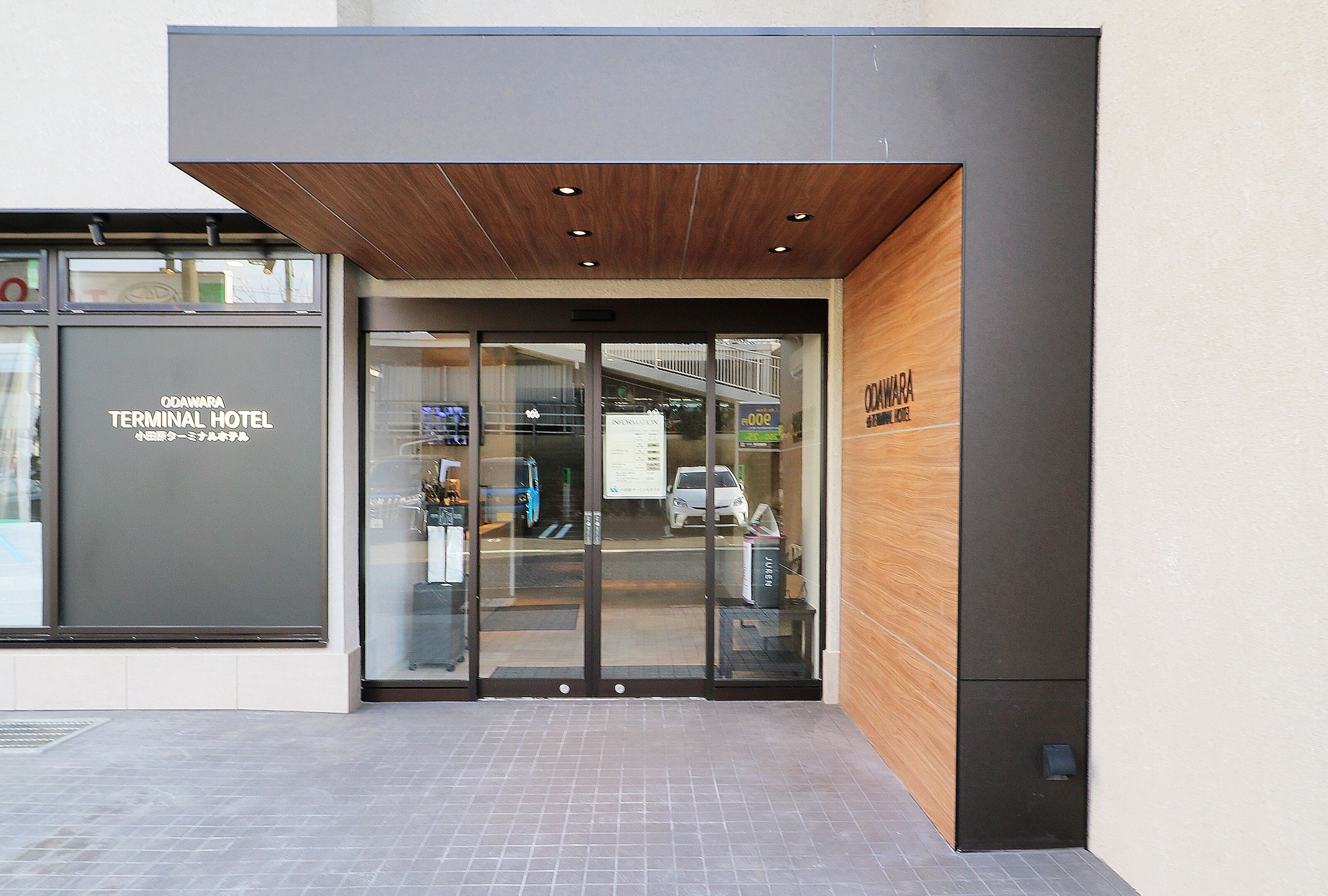 The entrance of Odaimura Terminal Hotel with glass doors and a wooden overhang.