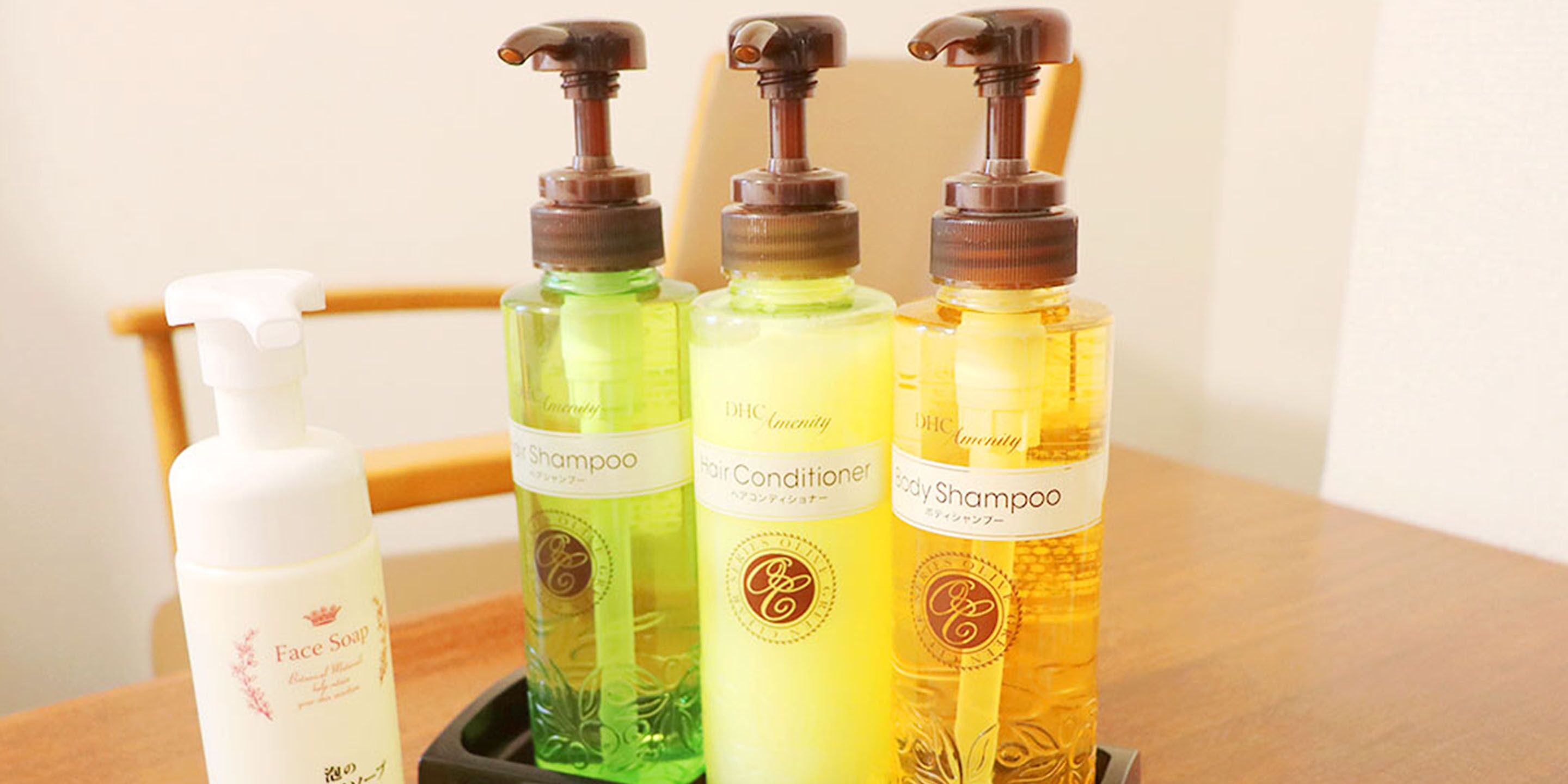 Quatre bouteilles de produits de soins capillaires sur une table en bois.