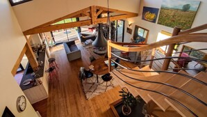 Un loft spacieux avec un escalier en bois, un coin repas et une vue sur l’extérieur.