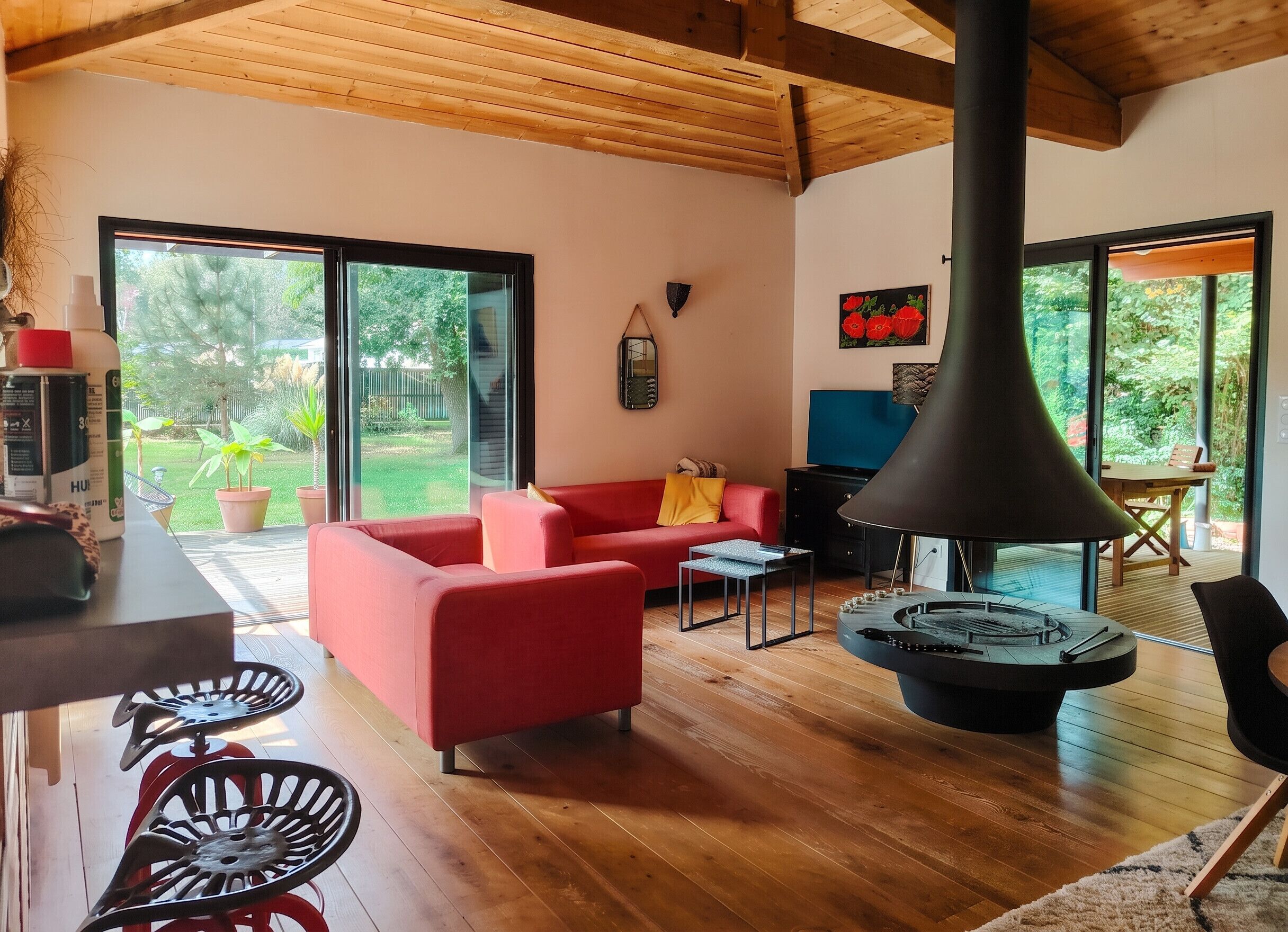 Ein modernes Wohnzimmer mit einem roten Sofa, einer schwarzen Tischlampe und einem Kaminofen.