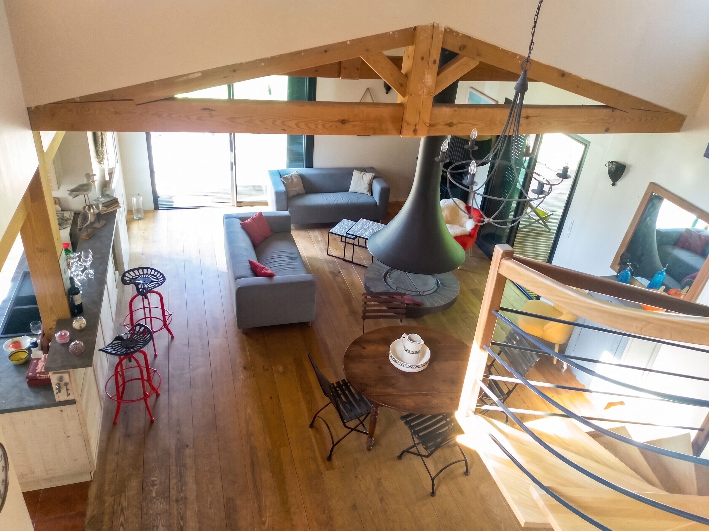 Un intérieur moderne avec un plafond en bois, un canapé, une table à manger avec des chaises et un escalier.