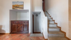 A hallway with a wooden cabinet, a staircase, and a door leading to another room. - Holiday home on the sea, immersed in nature – Accu is Prezzus E special (Villasimius)