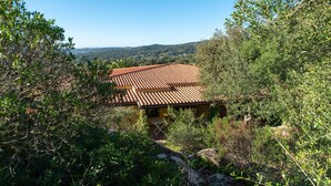 A building with a red-tiled roof surrounded by greenery.