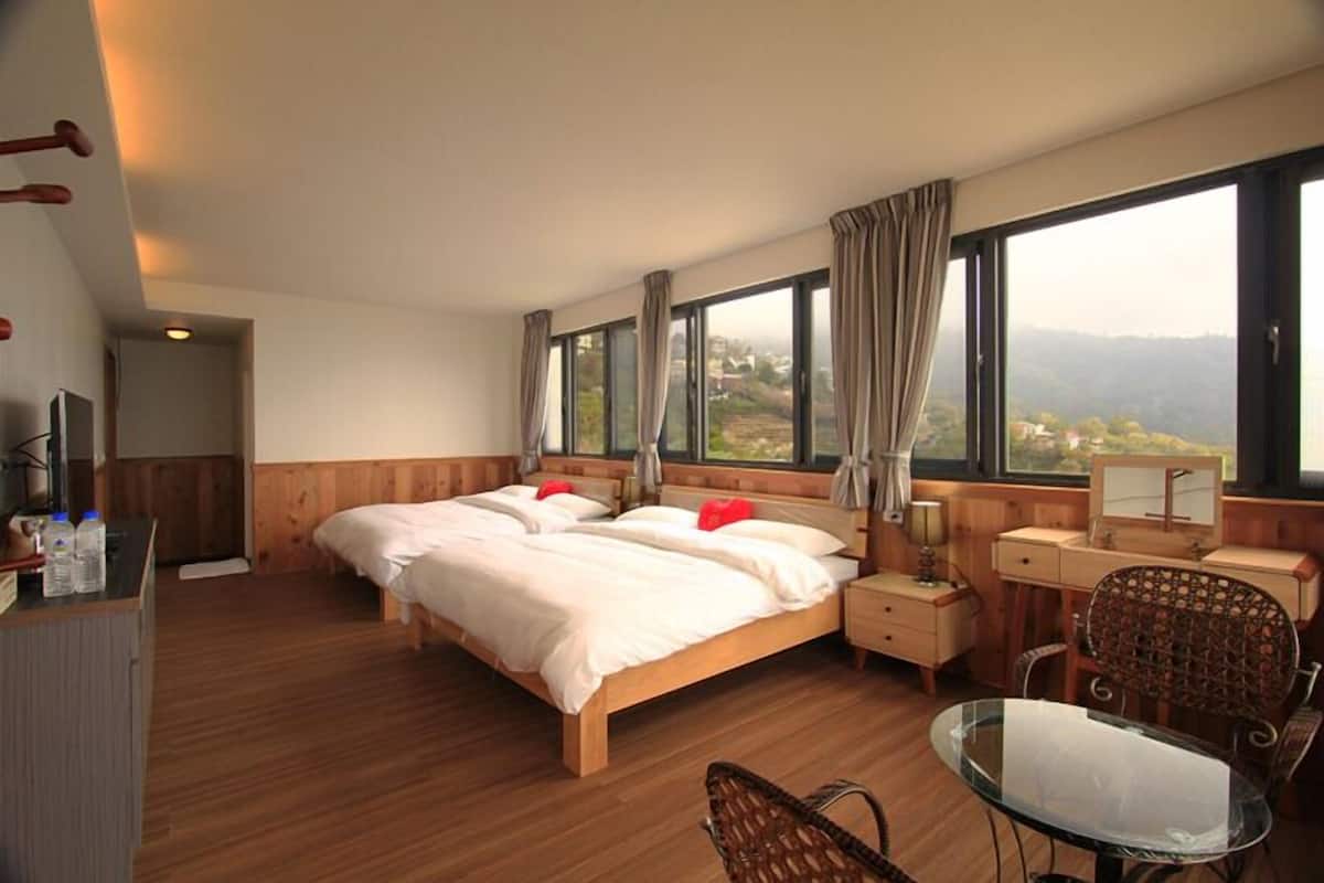 Habitación de hotel con una cama grande, un escritorio, una silla y vistas al exterior.
