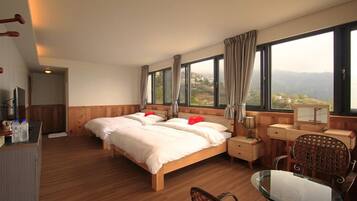 Une chambre d’hôtel avec un grand lit, un bureau, une chaise et une vue sur l’extérieur.