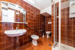 Une salle de bain équipée d’un lavabo, d’un bidet et d’une douche.