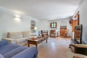 A living room with a sofa, a coffee table, and a bookshelf. - Secluded Villa with Pool, Wi-Fi, Air Conditioning and Terrace; Parking available (Alaró)