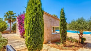 A modern building with a pool, surrounded by various trees and plants. - Beautiful and Spacious Villa in a Quiet Location with Large Pool, Terrace, Balcony & Garden (Campos)