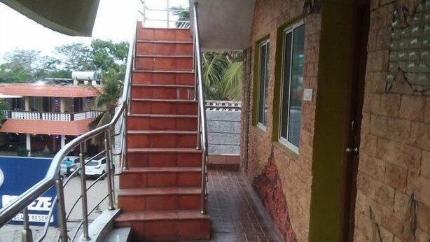 Eine Treppe führt zu einem Gebäude mit Fliesenboden und Metallgeländer.
