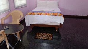 Ein Zimmer mit einem Bett, einem kleinen Tisch und einem Stuhl.