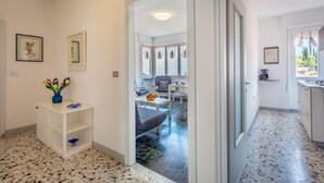 A modern interior with a kitchen, dining area, and a hallway leading to a bedroom. - Beautiful Nature and Historic Center – Liver 203 (Pieve di Tremosine sul Garda Brescia)