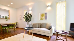 A living room with a sofa, a coffee table, a TV, and a dining area with chairs and a table. - Annex B Onna (Onna)