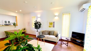 A living room with a sofa, a coffee table, a TV, and a dining area with chairs and a table. - Annex B Onna (Onna)