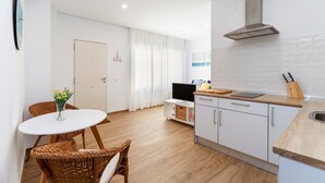 Une cuisine moderne avec des armoires blanches, un plan de travail en bois et une hotte de cuisine en acier inoxydable.