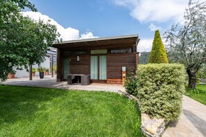 Una casa moderna con fachada de madera, un porche cubierto y un césped bien cuidado.