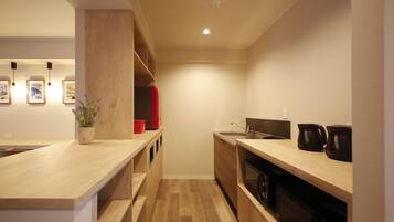 Una cocina moderna con mostradores de madera, un fregadero y un horno empotrado. Hay cuadros enmarcados en la pared y una planta en maceta sobre el mostrador.