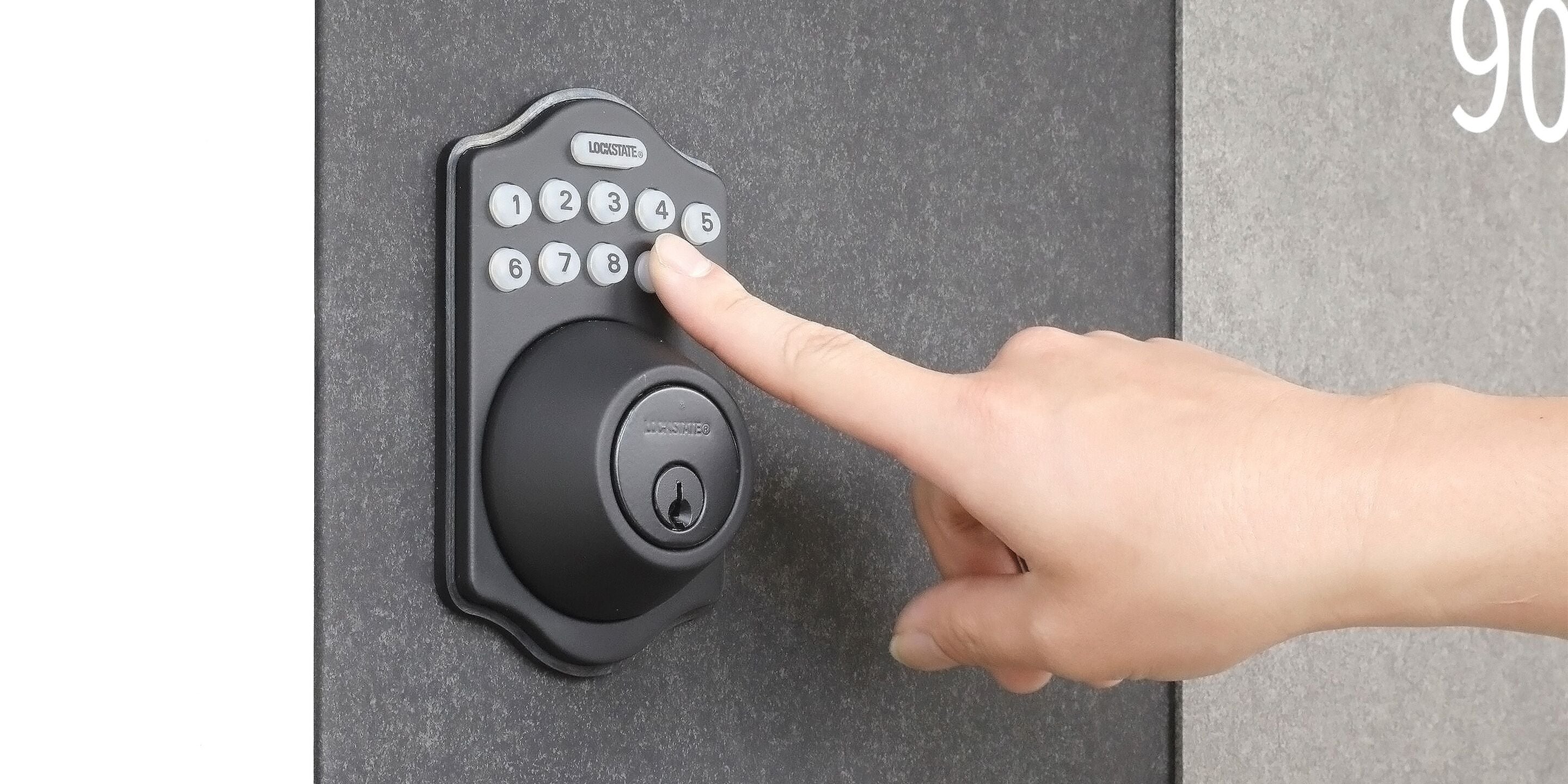 Una cerradura electrónica con teclado negro, con una mano pulsando el botón con el número 5.