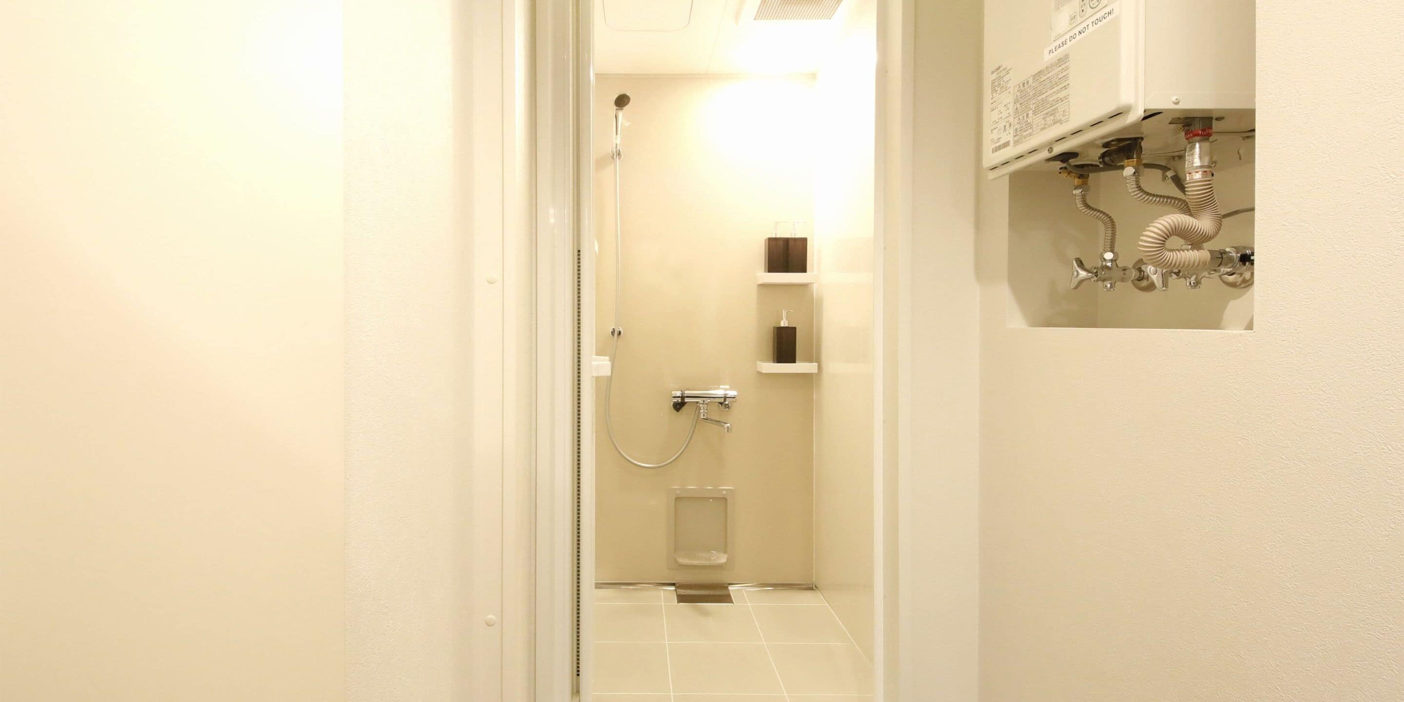 Un baño estrecho con ducha, inodoro y lavamanos.