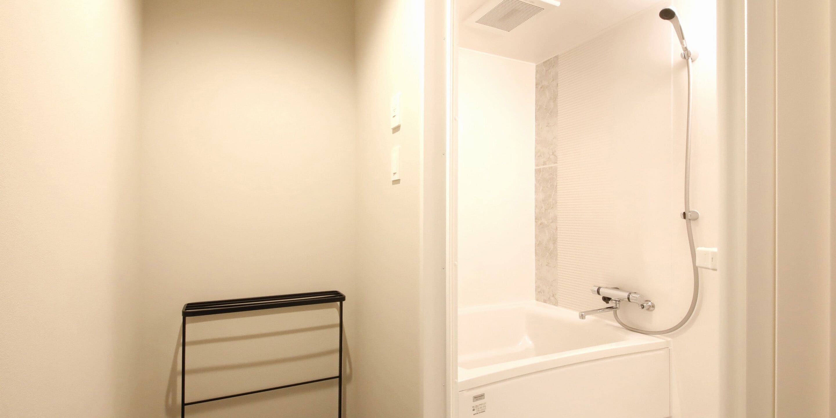 A bathroom with a shower, a bathtub, and a towel rack.