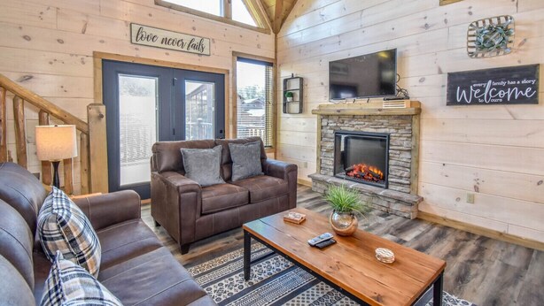 Una sala de estar acogedora con chimenea, sofás de cuero y detalles de madera.