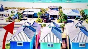 Zona residencial costera con casas y una playa al fondo.