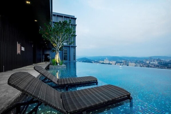 Relax by the infinity pool with a stunning city view.