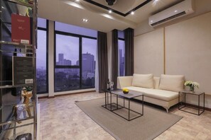 Relax in this urban retreat with a city view, featuring a comfortable sofa, side table, and coffee table.