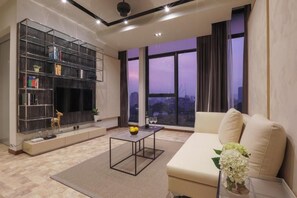 Relax in this stylish living room with a large bookshelf, comfortable sofa, and city view.