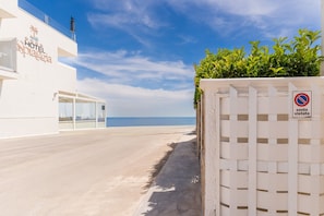 A hotel with a clear view of the sea, a no parking sign, and a white building facade.