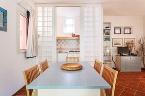 Uma área de refeições com mesa, cadeiras e uma tigela decorativa.
