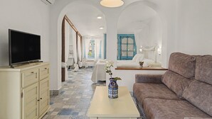 Ein modernes Wohnzimmer mit Fernseher, Sofa und einem Tisch mit einer Vase.