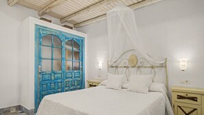 A bedroom with a bed, a nightstand, a bedside table, a wardrobe, and a ceiling fan. - Charming Apartment with Pool, Terrace, Air Conditioning and Wi-Fi (Conil)