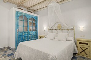 Een slaapkamer met een bed, nachtkastje, kledingkast en plafondventilator.