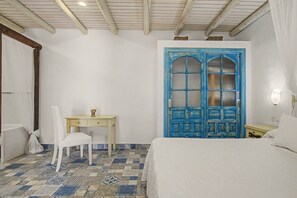 A bedroom with a bed, a desk, and a chair.