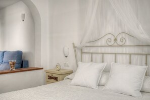 Une chambre à coucher comprenant un lit, une table de chevet, une horloge et un luminaire fixé au mur.