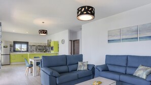 A modern living room with two sofas, a coffee table, and a dining area with chairs. - Modern Holiday Home ''Casa Toria'' with Private Pool, Air Conditioning (Conil de la Fontera)