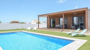 A modern house with a swimming pool, outdoor seating, and a covered patio. - Modern Holiday Home ''Casa Toria'' with Private Pool, Air Conditioning (Conil de la Fontera)