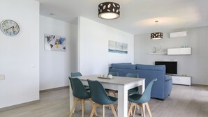 A modern living space with a dining table, chairs, a sofa, and a television. - Modern Holiday Home ''Casa Toria'' with Private Pool, Air Conditioning (Conil de la Fontera)